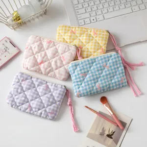 Detalle de cuatro bolsas acolchadas de cuadros con lazos rosas y borlas suaves