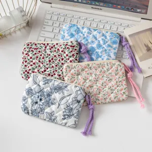 Set de cuatro bolsas acolchadas de flores sobre portátil blanco, detalle de organización