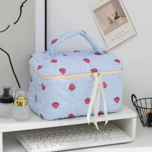 Borsa per cosmetici trapuntata a quadretti blu con dei simpatici motivi a fragola.