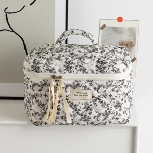 Close-up detail of the elegant floral quilted cosmetic bag with a convenient top handle