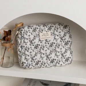 Detailed macro view of quilted floral cosmetic bag featuring elegant black flower patterns