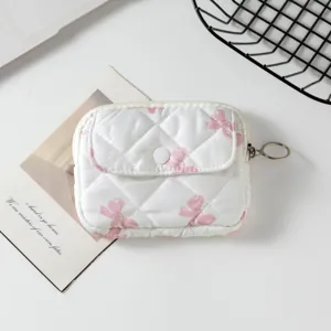 Primer plano de un mini bolso acolchado con lazos rosas y un anillo metálico.