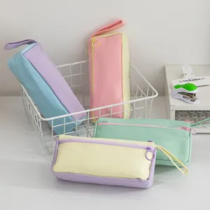 Detail showing four pastel patchwork canvas pencil cases in a minimalist desktop setting