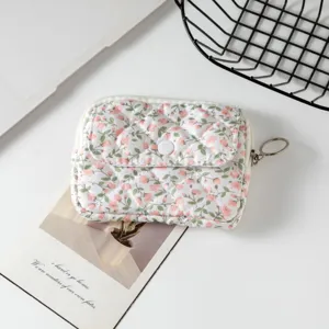 Vista detallada de una mini bolsa de almacenamiento acolchada con flores para auriculares