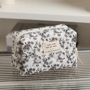Close-up of quilted floral makeup bag featuring an elegant fabric mood text label