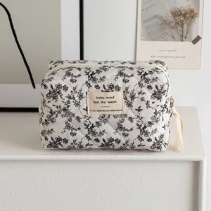 Floral printed quilted makeup bag for travel with zipper and decorative quote label