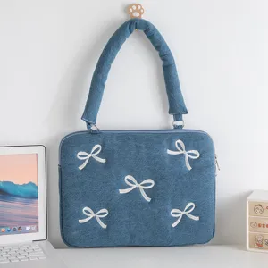 Detailansicht einer Denim-Laptophülle mit weißen Bogenstickereien und gepolstertem Griff.