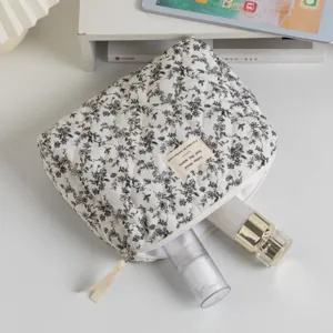 Quilted floral makeup bag showing interior storage capacity with skincare bottles.