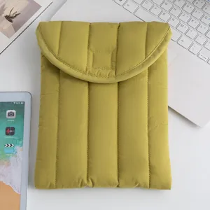 Vista detallada de una funda acolchada amarilla para tabletas de 13 pulgadas en un escritorio