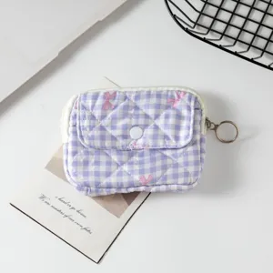 Detalle de mini bolsa acolchada de cuadros morados con botón a presión