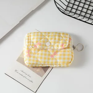 Detalle de mini estuche de cuadros amarillos con lazos rosas y tirador de aro