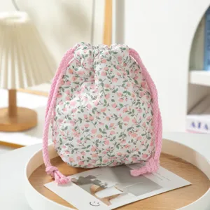 Macro view of the quilted floral pattern and pink drawstring on a fabric storage pouch