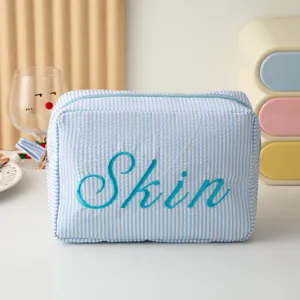 Vue détaillée de la trousse de maquillage rayée avec broderie Skin bleue