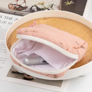 Close-up view showing the interior and inner pocket of a pink quilted cosmetic bag with bows