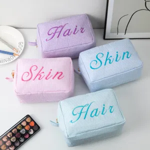 Collection de trousses de maquillage rayées pastel avec broderie Hair et Skin