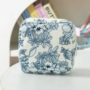 Piccola borsa cosmetica quadrata in velluto a coste con stampa floreale blu e pratica chiusura lampo.