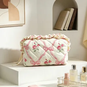 Gesteppte Kosmetiktasche mit Blumenmuster, rosa Schleifen und eleganten Rüschenrändern