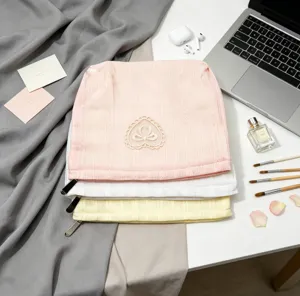 Close-up of pink ribbed makeup bags featuring a delicate embroidered heart patch