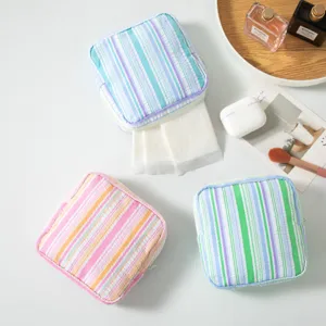 Detail view of striped seersucker storage pouches for sanitary napkins in three pastel colors.