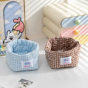 Détail de deux jolis paniers de rangement en tissu à carreaux bleu et marron.