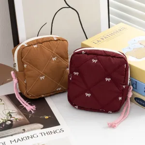 Two elegant quilted cosmetic pouches with bow embroidery and pink rope zipper pulls