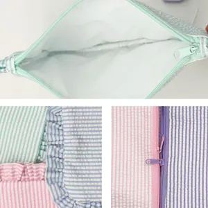 Detailed view of striped seersucker makeup bag showing inner lining and ruffles detail