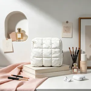 Detalle de un neceser acolchado blanco tipo nube en un tocador de estilo minimalista.