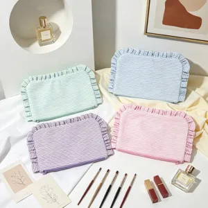 Close-up of four pastel seersucker striped makeup bags with decorative ruffled borders
