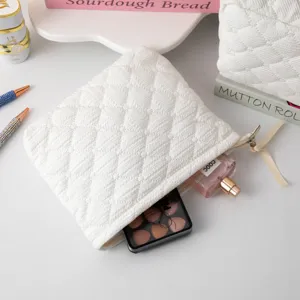 Neceser acolchado blanco con paleta de sombras de ojos y perfume en su interior