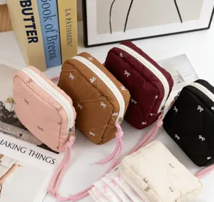 Detailed view of quilted bow storage pouches in multiple colors with zipper closure