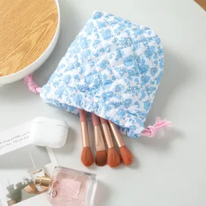 Detailed macro view of the blue floral quilted drawstring cosmetic bag with pink rope