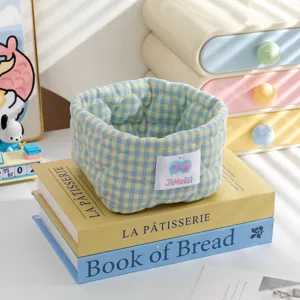 Panier de rangement en tissu à carreaux bleu et jaune posé sur des livres pour le bureau