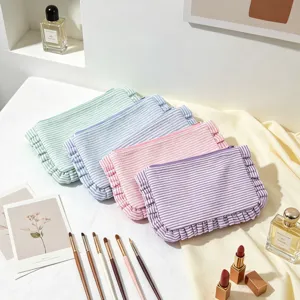 Aesthetic seersucker striped makeup bags with ruffle edges in various pastel colors.