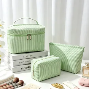Lot de trois trousses de maquillage de voyage en seersucker rayé vert avec zips.