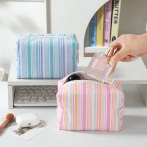 Lifestyle scene showing the seersucker striped makeup bag with beauty accessories.