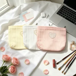Detailed view of fresh pastel bow cosmetic pouches in yellow, white, and pink colors.
