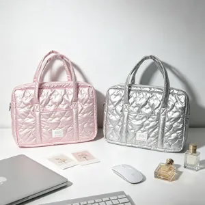 Heart quilted PU leather laptop sleeves in pink and silver shown on a white desk setup