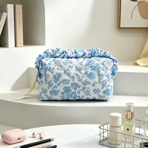 Elegante gesteppte Kosmetiktasche mit blauem Blumenmuster und Rüschenrand