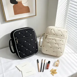 Dos bolsos acolchados con lazos en una mesa soleada con accesorios.