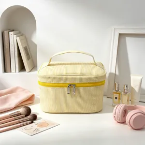 Vue détaillée de la grande trousse de maquillage rayée jaune en seersucker avec poignée solide