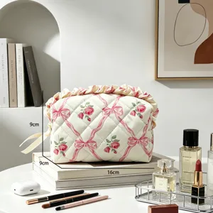 Detailansicht einer gesteppten Kosmetiktasche mit floralem Muster und elegantem Rüschenrand