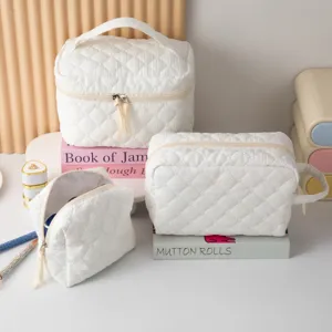Detalle de juego de neceseres acolchados blancos para viaje y almacenamiento de maquillaje