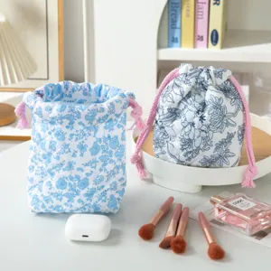 Floral quilted makeup bag with pink drawstring closure for portable cosmetic storage.