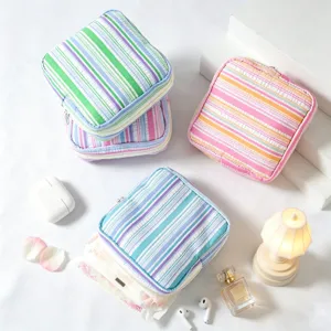 Detailed view of portable seersucker striped pouches for menstrual pads and cosmetics.