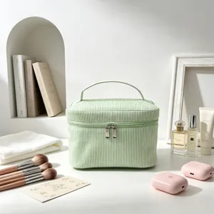 Vue détaillée d'une trousse de maquillage en seersucker à rayures vertes ici.