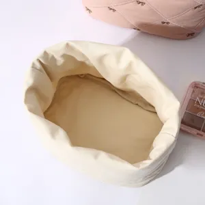 Detail view of the spacious cream canvas interior of a quilted drawstring bag
