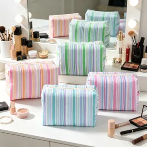 Detail of striped seersucker makeup bags on a bright vanity table with cosmetics.