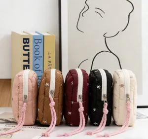 Collection of five colorful quilted makeup pouches featuring minimalist bow patterns