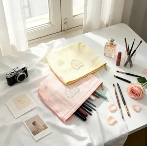 Detail shot of pink and yellow makeup bags with heart lace embroidery on white desk