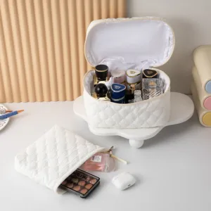 Vista detallada de la bolsa de maquillaje acolchada blanca con neceser a juego.